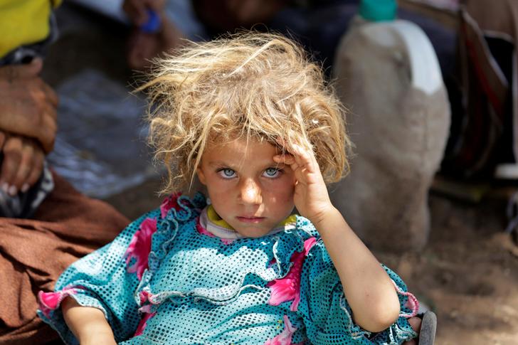 A girl from the minority Yazidi sect, fleeing the violence in the Iraqi town of Sinjar, rests at the Iraqi-Syrian border crossing in Fishkhabour, Dohuk province August 13, 2014. REUTERS/Youssef Boudlal